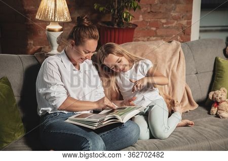 Reading Book. Mother And Daughter During Self-insulation At Home While Quarantined, Family Time Cozy