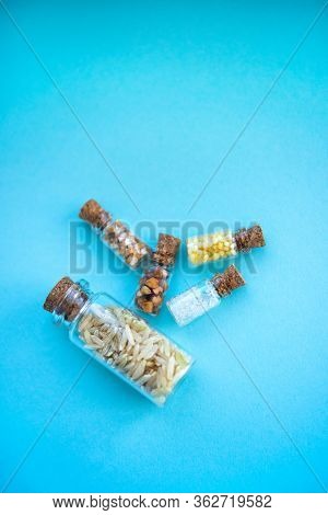 Vertical Picture With Soft Focus Of Five Tiny Glass Jar With Rice, Buckwheat, Millet, Sugar And Barl