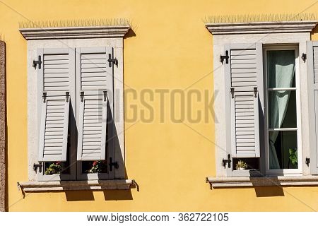 Two Windows With Grey Wooden Shutters With Spike Steel Sticks To Prevent Birds From Stopping, Especi