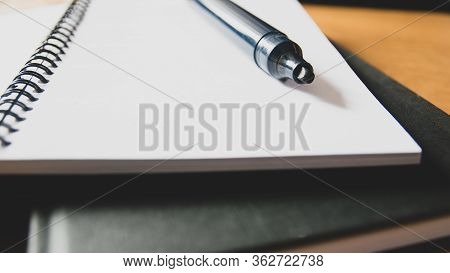 Front View Of Black Marker And School Notebook, Felt-tip Pen And Spiral Notepad On A Table. Low Angl