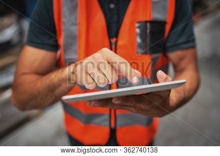 Close-up Of Man Hands Using Digital Tablet Computer While Standing In The Warehouse