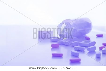 Pills Spilling Out Of A Pill Bottle On White. With Copy Space. Medicine Concept. Trand Tinted Image