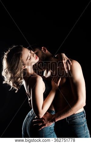 Young Couple In Blue Jeans Embracing Isolated On Black