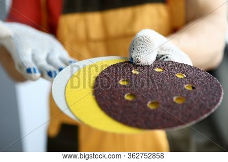 Close-up Of Male Hands Holding Orbital Sander Machine Discs. Man In Protective Gloves In Hardware Sh