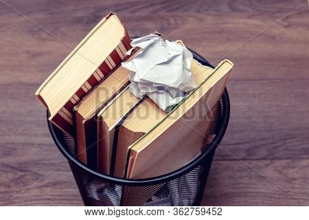 Books And Crumpled Paper In The Bin. Books That Do Not Read, Low-grade Literature_