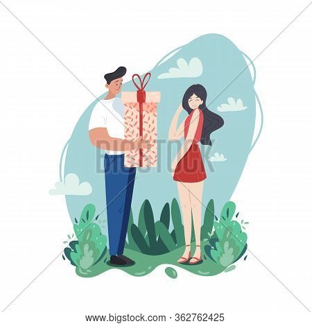 A Young Couple Of People Are Spending Their Time Together. Man Gives A Present To His Embarrassed Gi