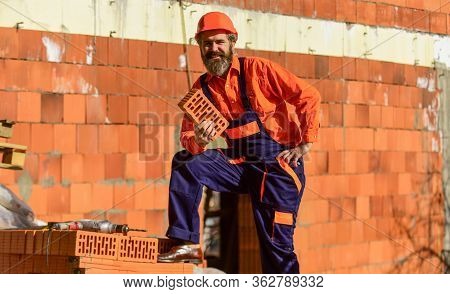 Happy Bearded Man Hold Brick. Brickwork. Man Takes Brick From The Pile. Male Construction Worker Hol