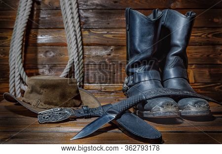 Cowboy Hat, Boots And Rope On Wooden Background