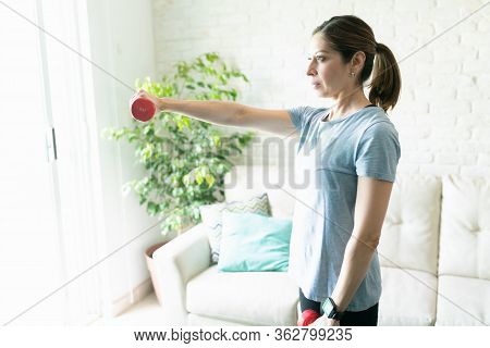 Profile View Of A Woman In Her 40s Strengthening Her Arms And Lifting Some Weigths At Home