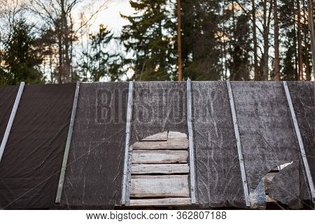 Torn Ruberoid Roofing Material On The Roof Of The House