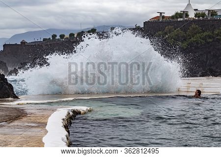 Porto Moniz Madeira - August 2, 2018: A Girl Bathes In A Natural Lava Pool During High Tides And Lar