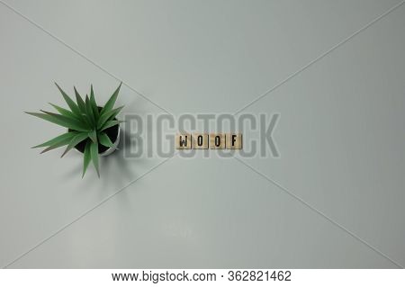 The Word Woof Written In Wooden Letter Tiles On A White Background
