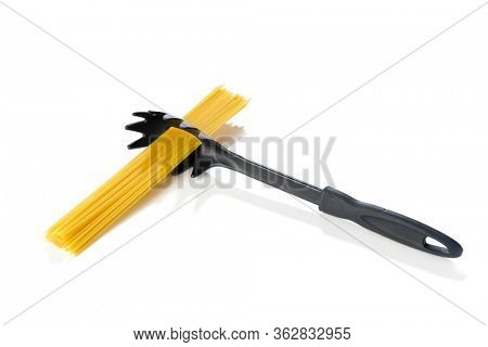 Life hack, measuring one serving of pasta with spaghetti spoon isolated on white background.  
