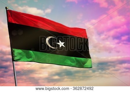 Fluttering Libya Flag On Colorful Cloudy Sky Background. Libya Prospering Concept.