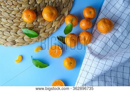 Top View Of Ripe Fresh Mandarins Or Tangerine Orangers With Green Leaves In Blue Background With Pla
