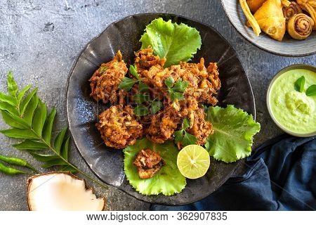 Indian Cuisine. Pakora Traditional Indian Deep-fried Snack. Pakoras On Black Plate With Coconut Chut