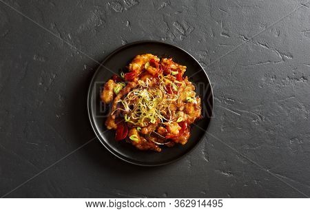 Spicy Garlic Fried Chicken (kkanpunggi). Asian Chicken In Sweet And Sour Sauce On Plate Over Black S