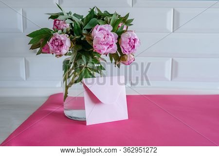 Bouquet Of Pink Peonies In Glass Vase Against White Background And Wooden Table. Mothers Day Card. B