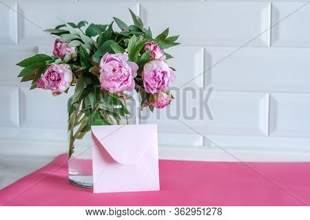 Bouquet Of Pink Peonies In Glass Vase Against White Background And Wooden Table. Mothers Day Card. B