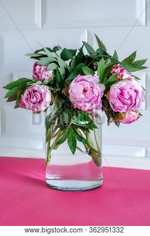 Bouquet Of Pink Peonies In Glass Vase Against White Background And Wooden Table. Mothers Day Card. B