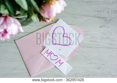 Bouquet Of Pink Peonies In Glass Vase Against White Background And Wooden Table. Mothers Day Card. B