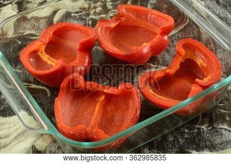 Lightly Baked Fresh Red Bell Pepper Halves In Glass Baking Dish Ready For Stuffing With Ingredients