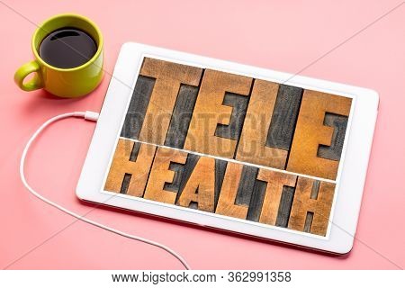 telehealth - word abstract in vintage letterpress wood type on a digital tablet, health, healthcare and telecommunication technology concept