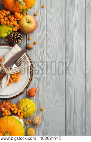 Thanksgiving Day Concept. Top View Vertical Photo Of Plate Knife Fork Napkin Rowan Berries Vegetable