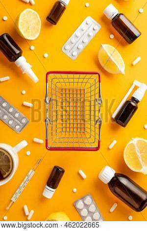 Illness Concept. Top View Vertical Photo Of Empty Shopping Cart Medicines Spray And Syrup Bottles Pi