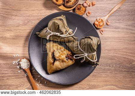 Zongzi, Steamed Rice Dumplings On Wooden Table Bamboo Leaves, Food In Dragon Boat Festival Duanwu Co