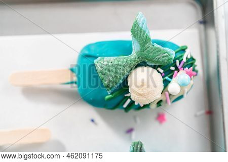 Mermaid Cakesicles With Drizzled Chocolate, Chocolate Mermaid Tails, Seashells, And Sprinkles.