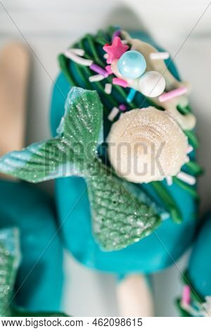 Mermaid Cakesicles With Drizzled Chocolate, Chocolate Mermaid Tails, Seashells, And Sprinkles.