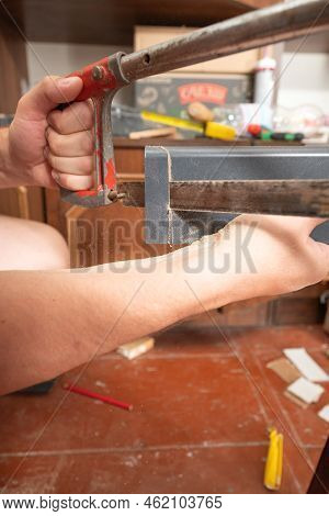 Trimming A Wooden Plinth With A Manual Jigsaw.