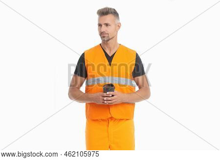 Serious Builder With Coffee Looking Aside. Guy In Safety Vest Having Coffee Break