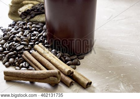 Coffee Beans Spilled Out Of A Canvas Bag Of Cinnamon And A Coffee Mug Onto A Table With A Place Of C