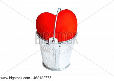 Large Red Heart Placed In A Steel Water Bucket Isolated On White Background. The Concept Of Being Vu