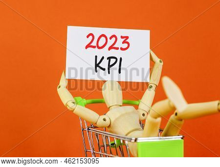 Kpi, Key Performance Indicator Symbol. White Paper With Words Kpi 2023, Human Model In Shopcart. Bea