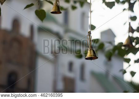 A Cute Little Windbell Hanging From A Branch. Bells On The Branches Of The Tree In The Courtyard Of