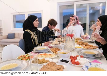 Muslim family making iftar dua to break fasting during Ramadan.
