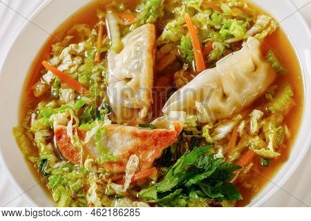 Close-up Of Asian Potsticker Gyoza Soup With Dumpling Of Ground Chicken, Napa Cabbage, Ginger, Celer