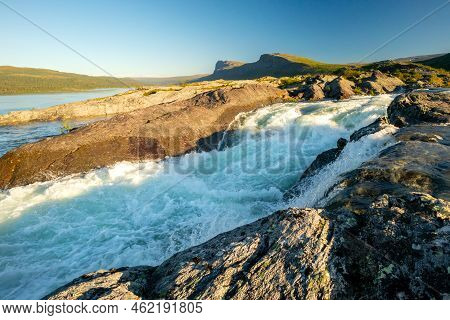 Golden Hour By The Rapids Of Stuor Muorkke Waterfall In Stora Sjofallet National Park, Sweden. Adven