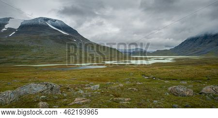 Lake Under The Moutains In Remote Arctic Valley On Cloudy Day Of Arctic Summer. Pierikjaure Or Bieri