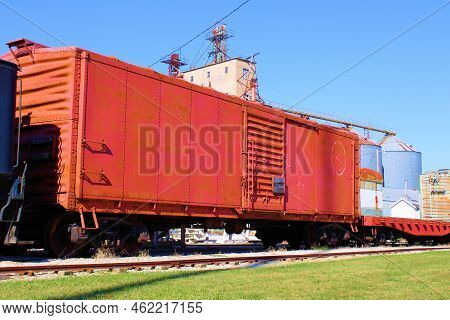 September 20, 2022 In Atchison, Ks:  Vintage Rail Car On Railroad Tracks With A Grain Elevator Beyon