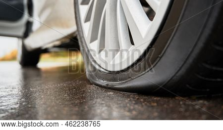 Close-up View Of Punctured, Flat Tire On Rear Wheel Of Automobile. Fault, Damage Wheel While Driving