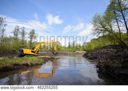 Excavator Near The Lake In Countryside. Cleaning And Making River More Deep