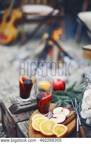 Two Glasses Of Hot Mulled Wine Drink With Citrus, Apples, Cinnamon Sticks, Cloves And Anise On Woode