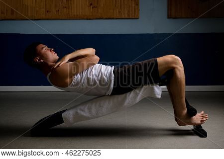 19 Year Old Teenage Boy Doing Situps On An Excercise Bench In A Tank Top