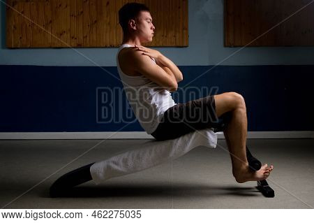 19 Year Old Teenage Boy Doing Situps On An Excercise Bench In A Tank Top