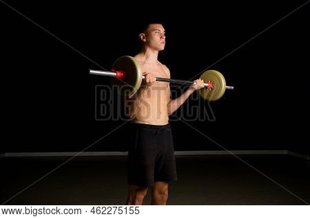 Shirtless 19 Year Old Teenage Boy Excercsing His Bicpes With A Barbell