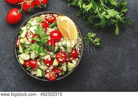 Bulgur Tabbouleh Salad With Fresh Tomatoes, Cucumbers, Parsley And Lemon Dressing. Traditional Middl